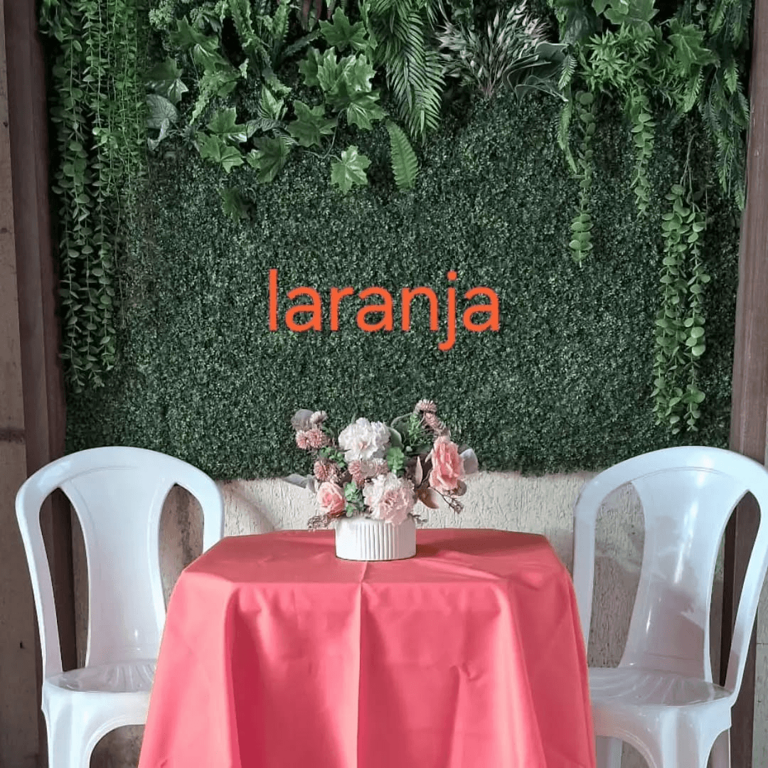 Mesa com toalha Oxford laranja e cadeiras brancas