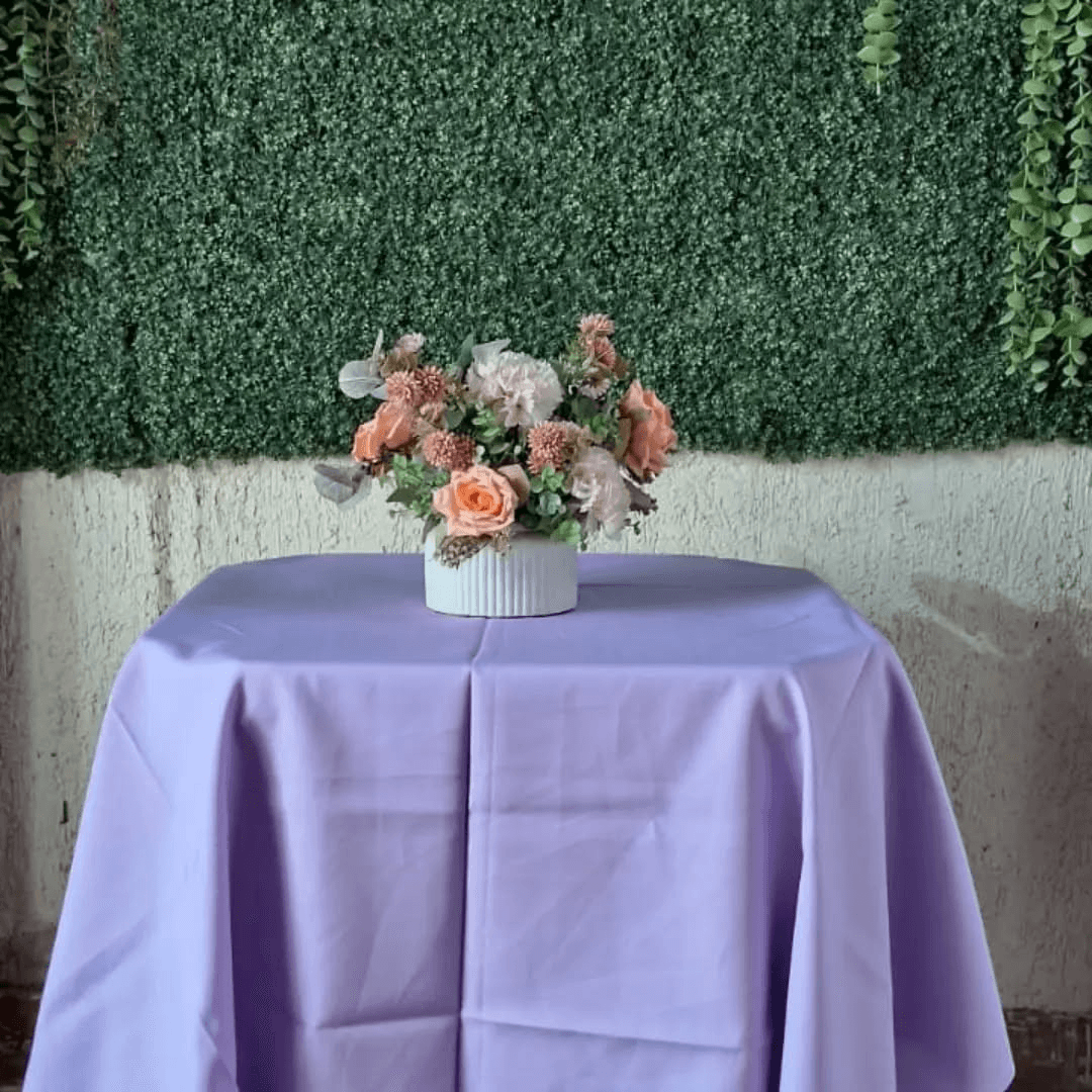 Mesa com toalha Oxford lilás e cadeiras brancas